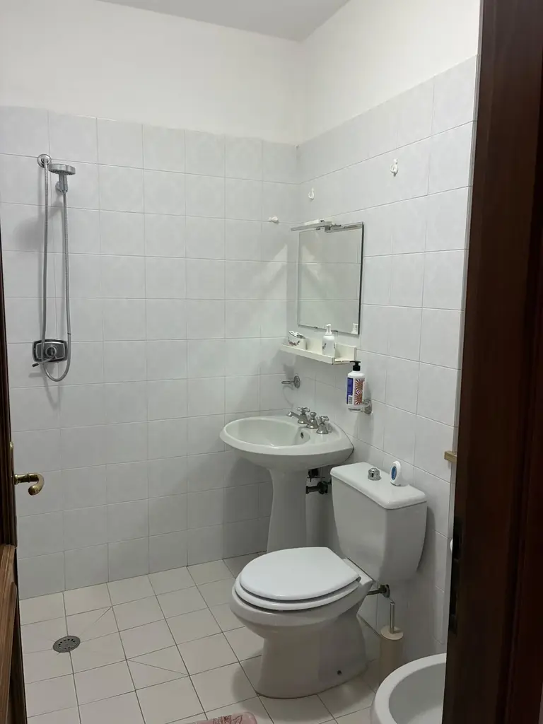 Il bagno con la doccia a filo pavimento, il lavabo e lo specchio