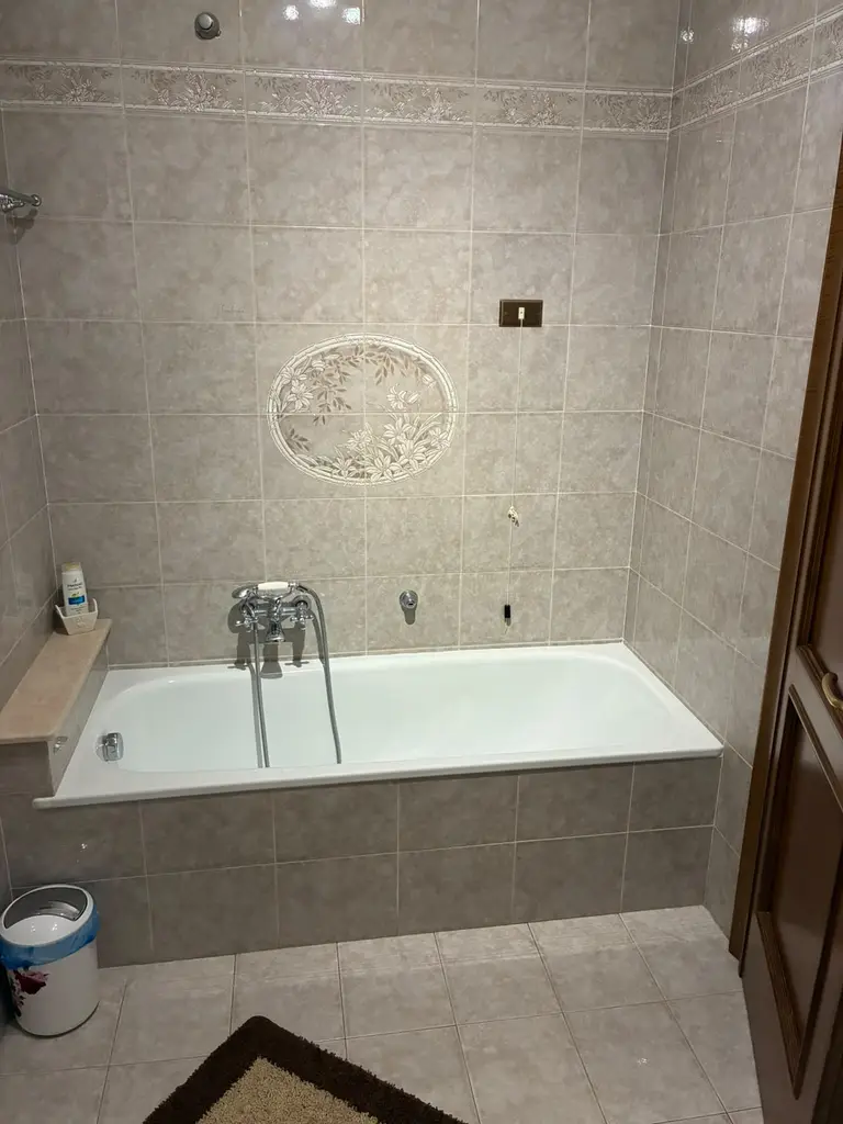 Il bagno principale con la vasca e le piastrelle decorate a fiori