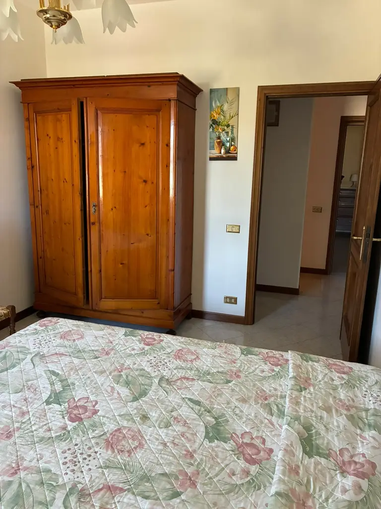 Il grande armadio in legno della camera, accanto alla porta