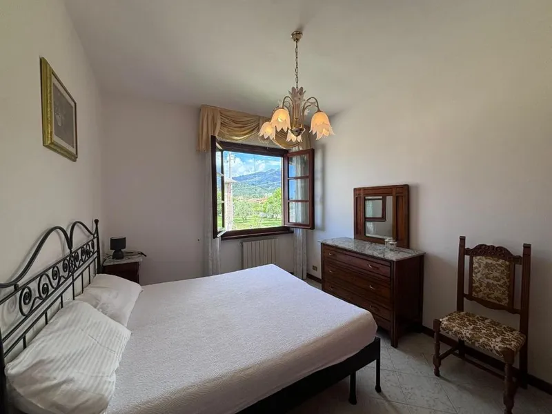 La camera padronale con il letto matrimoniale in ferro battuto e la finestra sulle colline