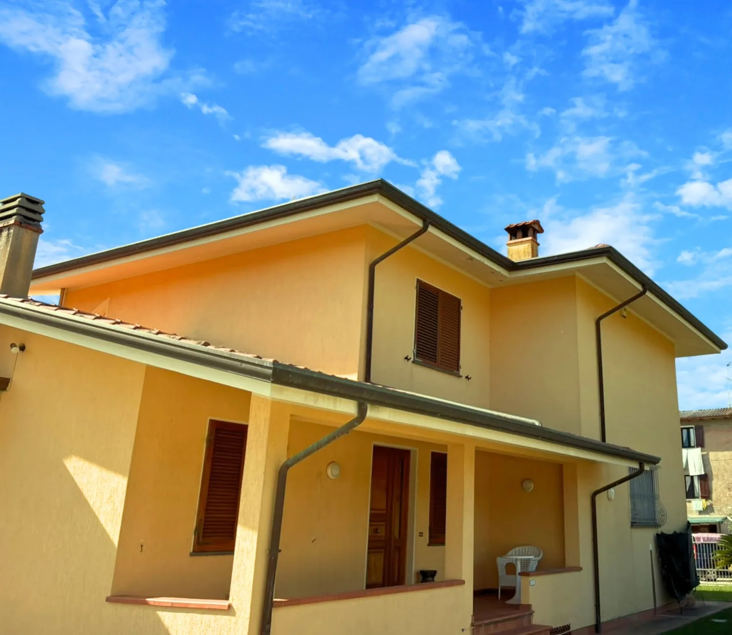 Lemon Villa, la facciata color limone con il portico sotto il cielo azzurro
