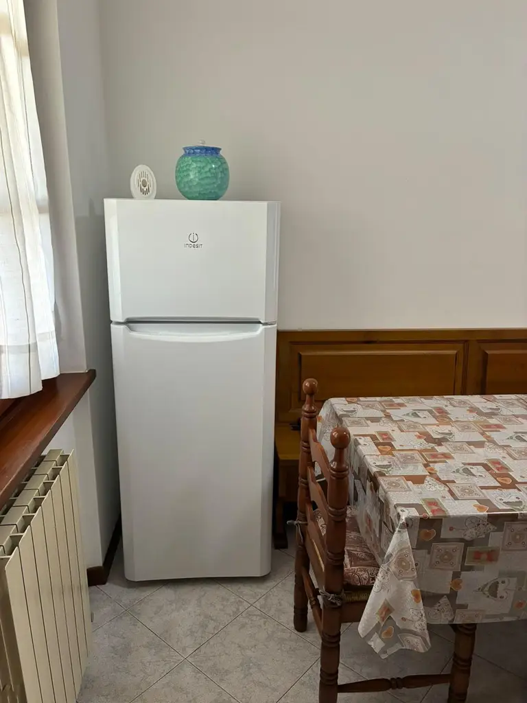 L'angolo della cucina con il frigorifero e il tavolo