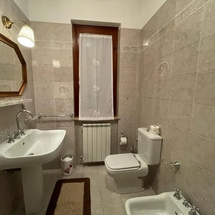 Il bagno del piano terra con lavabo, specchio e finestra